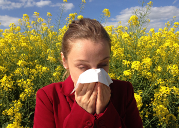 girl blowing her nose from allergies